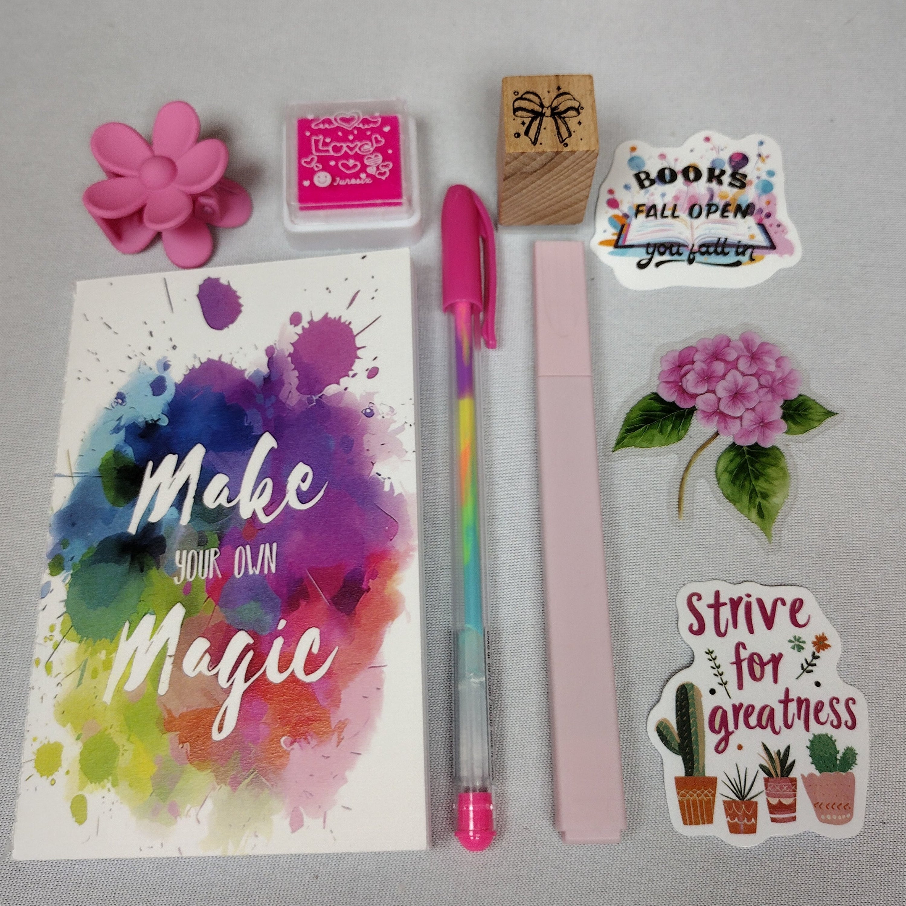 Mini Journaling Bookish Bundle Gift Set includes stationery items such as a mini notebook, hair clip, ink pad & stamp, gel pen, highlighter, and free stickers curated by you.